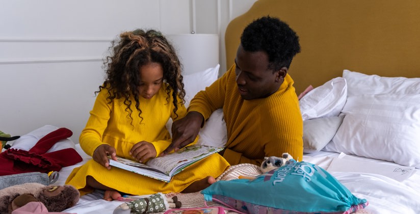 Dochter en vader die samen in een boek lezen