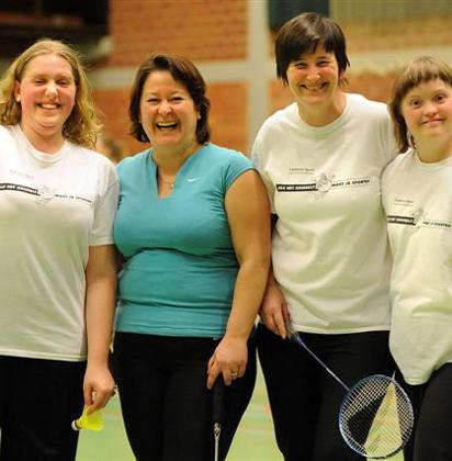 Vier vrouwen met een badminton outfit poseren voor de foto