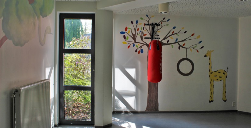 Speelruimte van leefgroep met bokszak en tekeningen op de muren