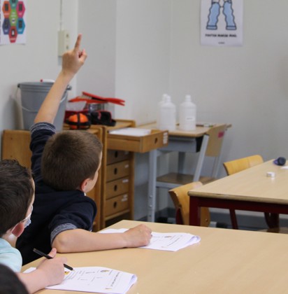 Leerling die zijn hand opsteekt om iets te zeggen