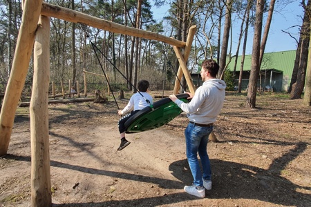 Begeleider en kind aan het spelen in de speeltuin aan Tierlantijn Lange Wapper