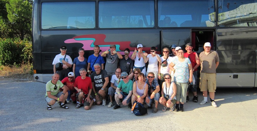 Groep mensen poseert voor reisbus