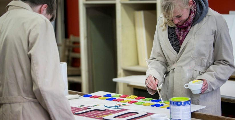 Vrouw schildert houten letters