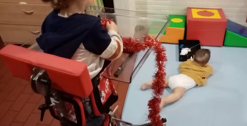 jong kindje in speciale stoel die rechtstaan mogelijk maakt