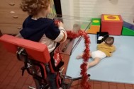 Thumbnail: jong kindje in speciale stoel die rechtstaan mogelijk maakt