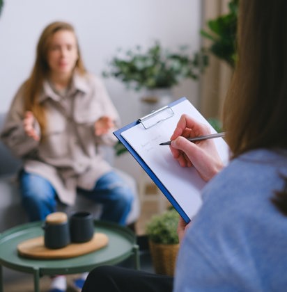 een vrouw die aan het vertellen is en een therapeut die noteert