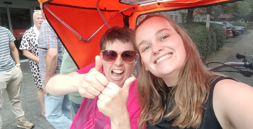 Riksha zorgfiets cliënt en medewerker - steun ons 2025