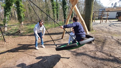 Artikelfoto: Begeleider Jaimy speelt met kinderen op een schommel 