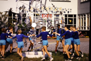 Thumbnail: Oude foto van kinderen die in een kring rond kunstwerk dansen