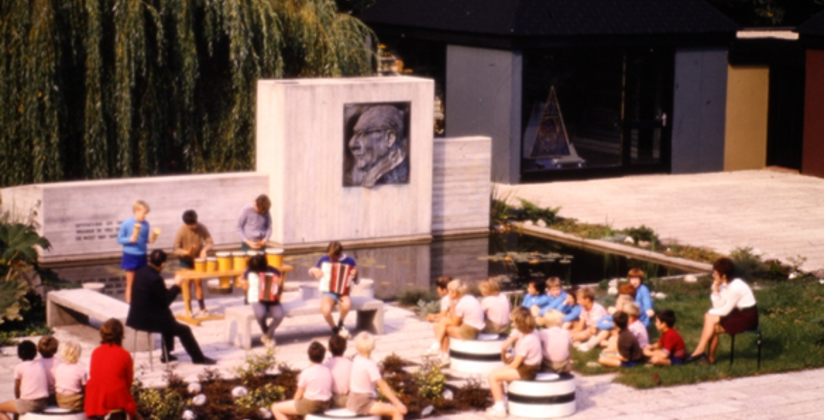 Oude foto van kinderen die bij vijver zitten